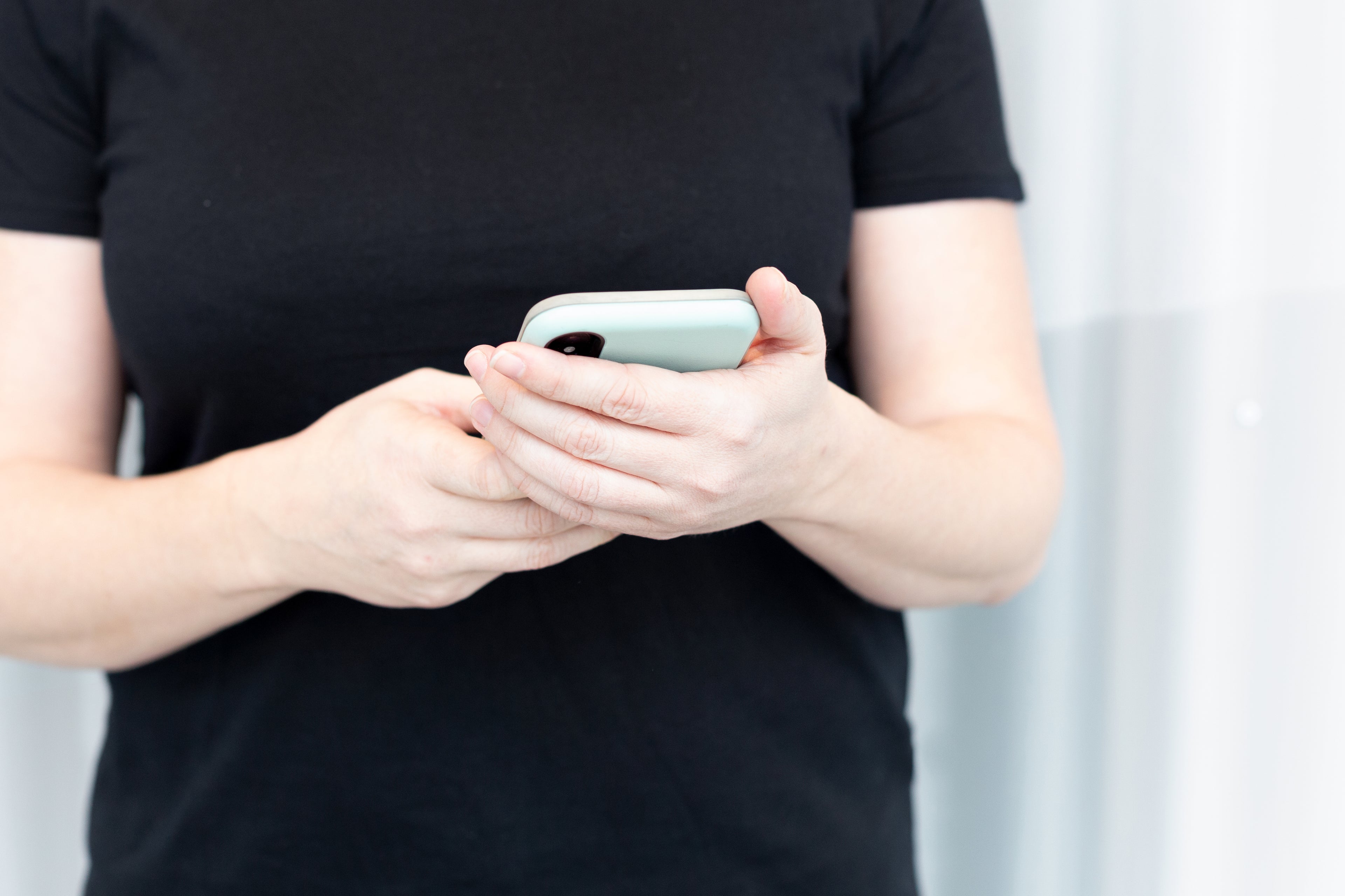 woman sends text on smartphone